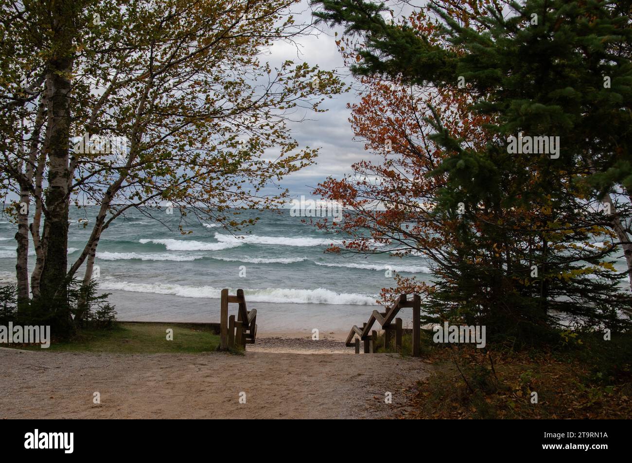 Vista fredda delle onde che si infrangono sulla spiaggia la sera d'autunno Foto Stock