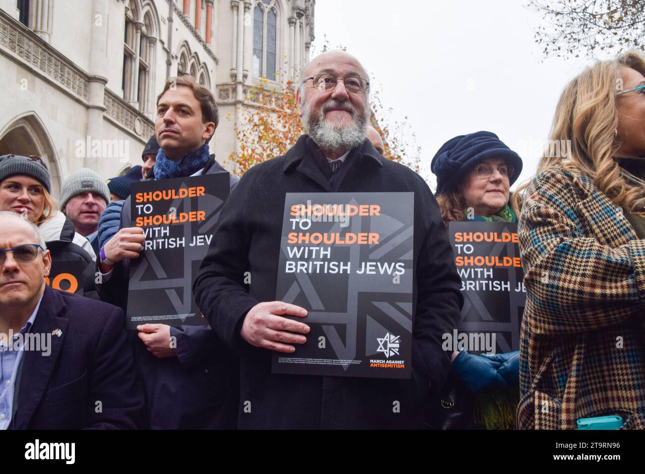 Londra, Regno Unito. 26 novembre 2023. Il rabbino capo del Regno Unito Ephraim Mirvis (al centro) tiene un cartello che indica "spalla a spalla con gli ebrei britannici" durante la manifestazione. Migliaia di manifestanti pro-Israele hanno marciato nel centro di Londra contro l'antisemitismo e hanno chiesto il rilascio di ostaggi israeliani detenuti da Hamas a Gaza. Credito: SOPA Images Limited/Alamy Live News Foto Stock