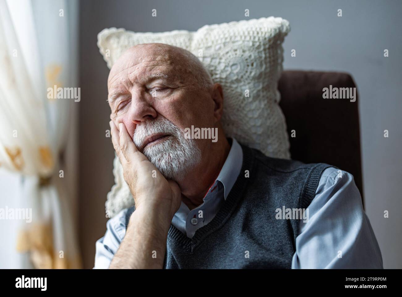 Uomo anziano che dorme in una poltrona a casa Foto Stock