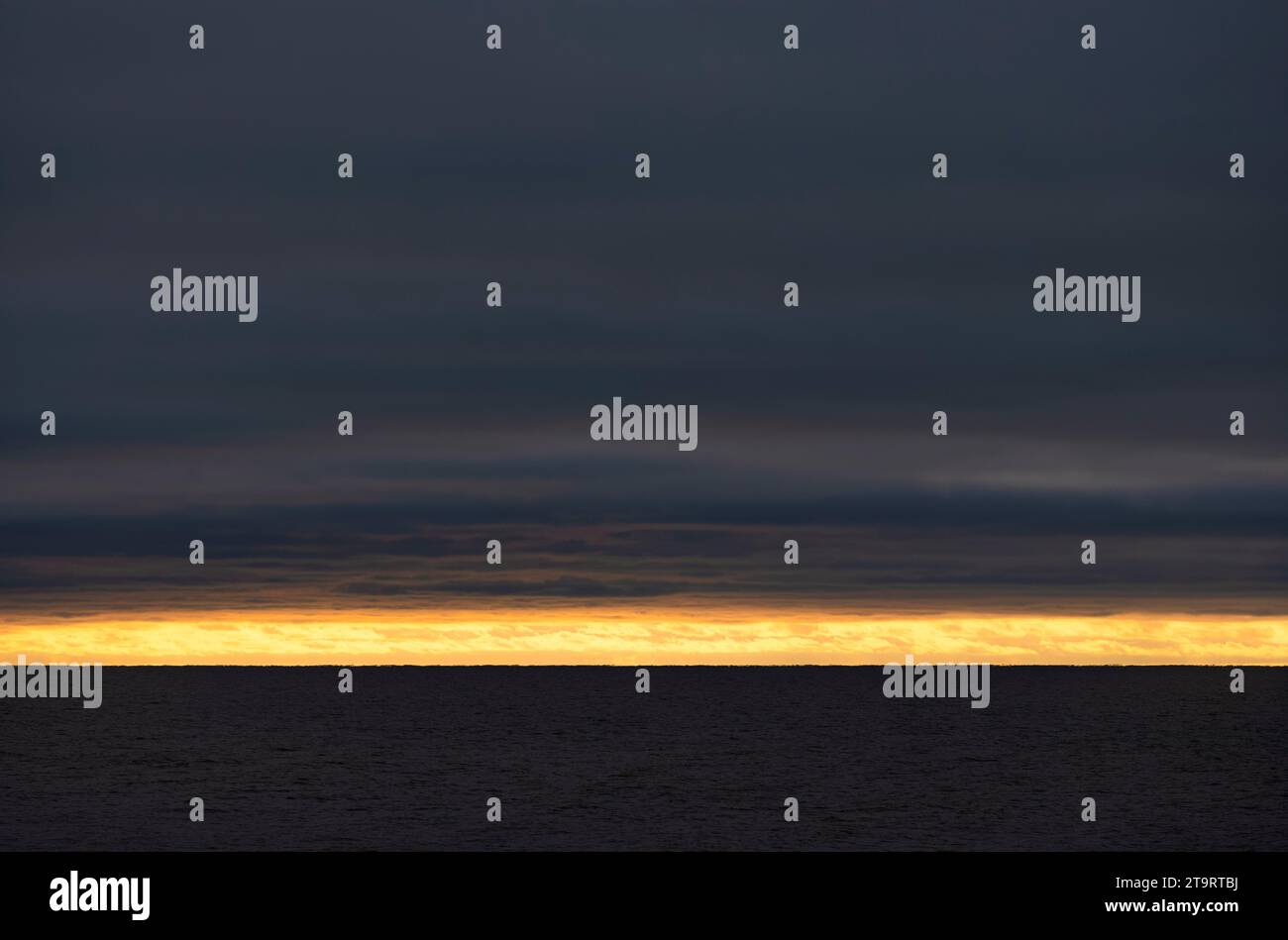 Tramonto sul mare, stretta striscia di sole all'orizzonte, nuvole, buio, Rantum, Mare del Nord isola di Sylt, Frisia settentrionale, Schleswig-Holstein, Germania Foto Stock