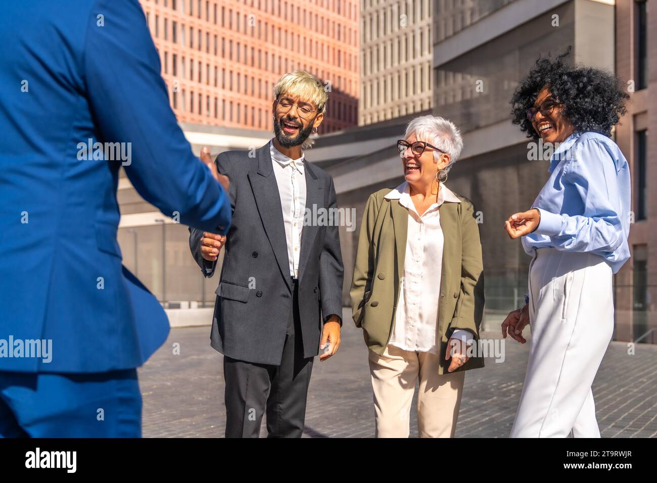 Gruppo multietnico di uomini d'affari che stringono la mano quando arrivano a un punto d'incontro fuori da un edificio finanziario Foto Stock