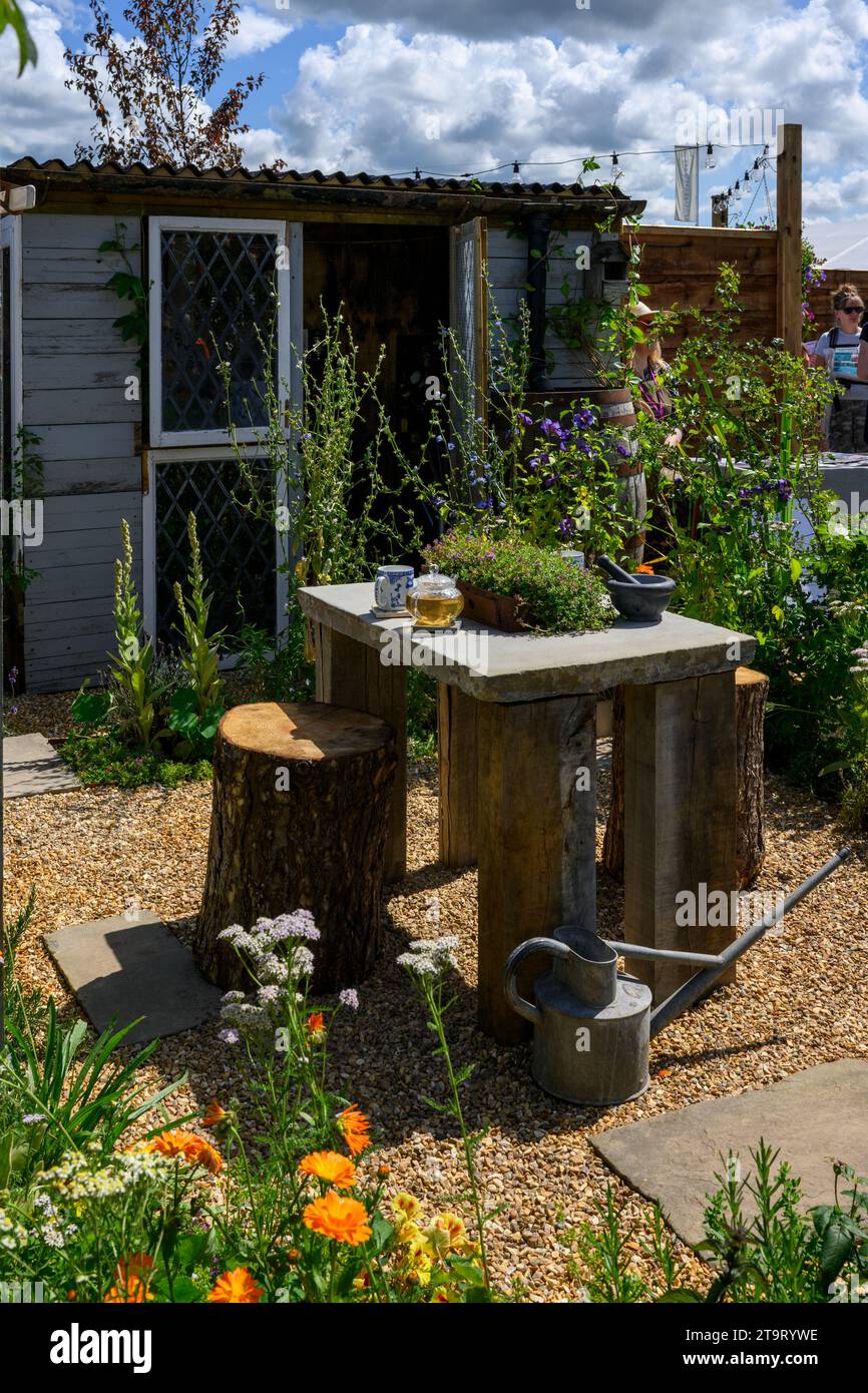 Partecipazione al concorso Apothecary Terrace Garden (tronchi ribaltati come posti a sedere, capannone in legno) - RHS Tatton Park Flower Show 2023, Cheshire Inghilterra Regno Unito. Foto Stock