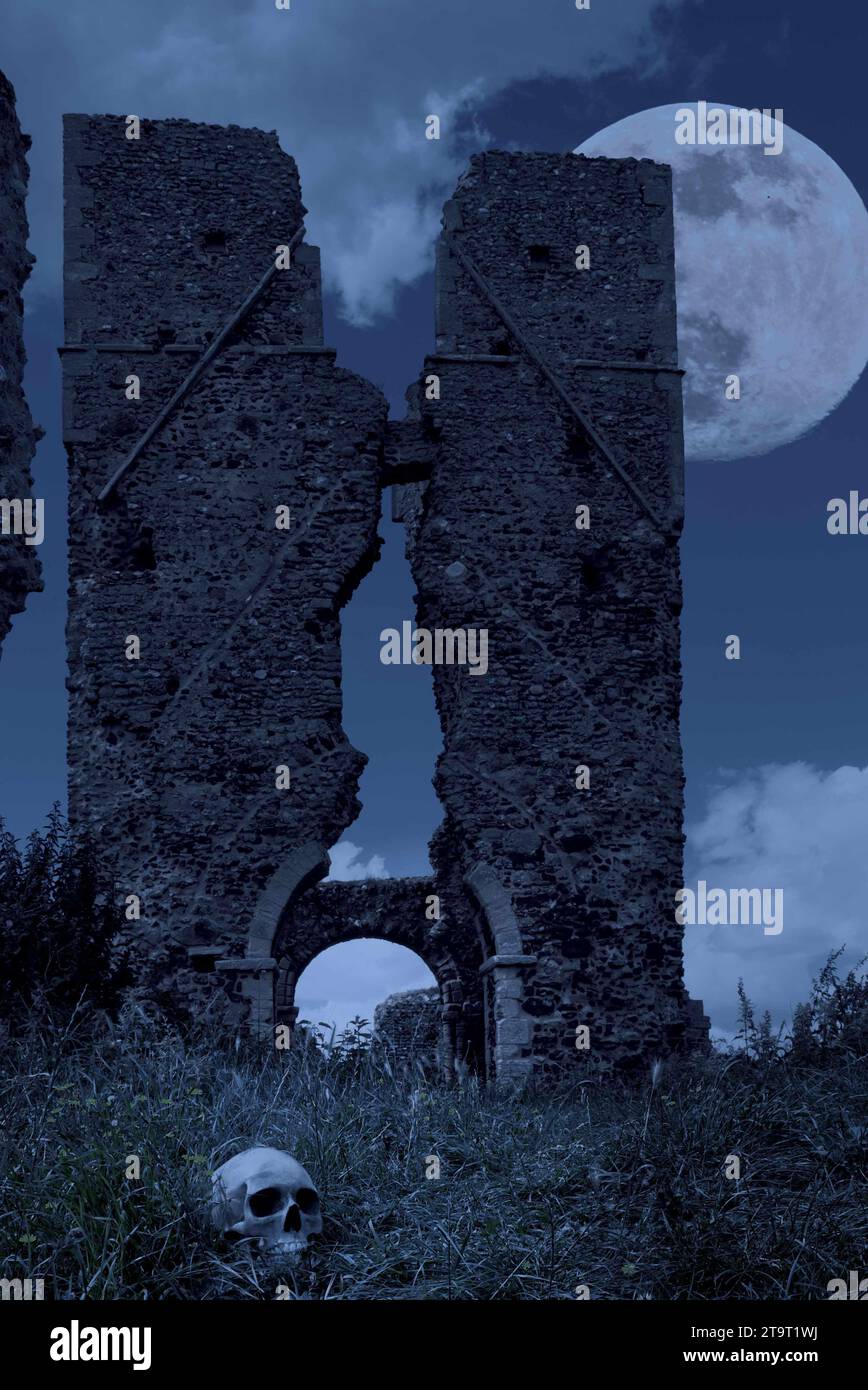 torre della chiesa in rovina con un teschio umano (replica) nell'erba in primo piano. Foto Stock