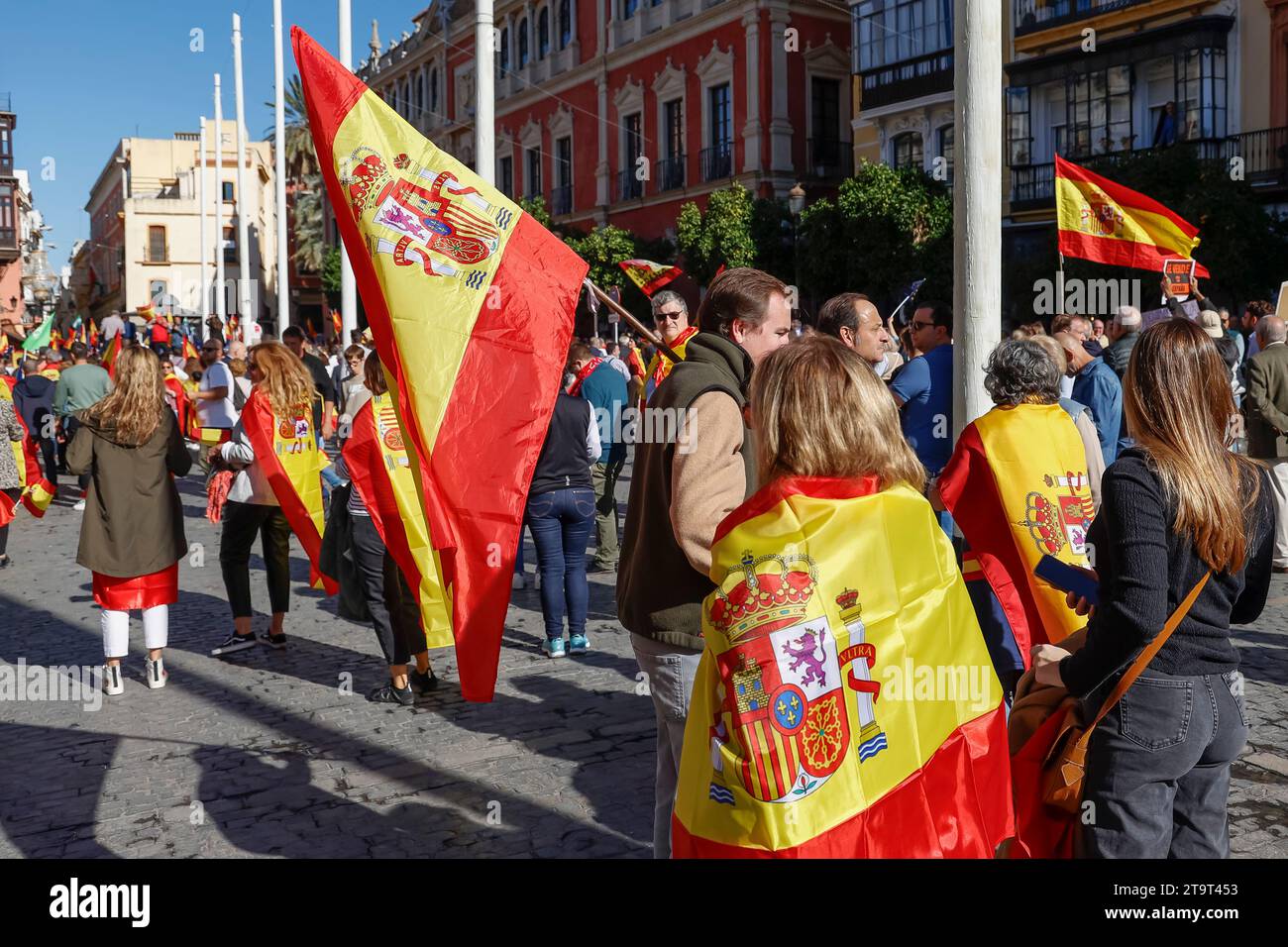 Gente drappeggiata con bandiere spagnole a una manifestazione politica a Siviglia, Andalusia, Spagna Foto Stock
