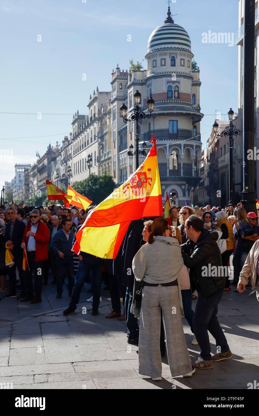 Gente che porta bandiere spagnole a una manifestazione politica a Siviglia, Andalusia, Spagna Foto Stock
