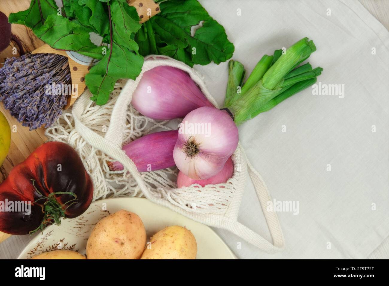 Scalogni cipolle e altre verdure. Vari tipi di verdure. Barbabietole, pomodori, patate. Stile country. Agricoltura e raccolta. Vista dall'alto. Foto Stock