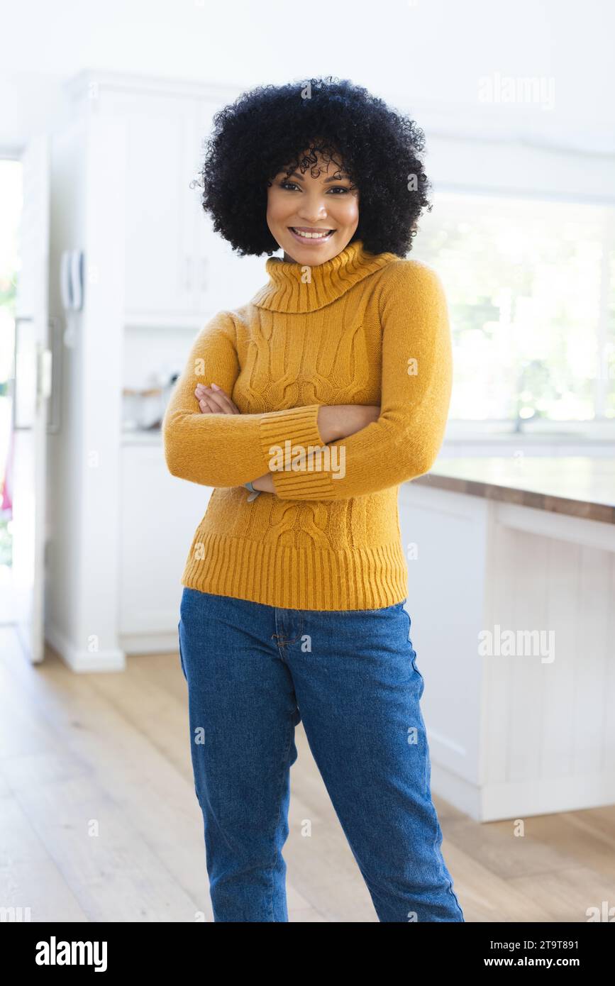 Felice donna afro-americana in piedi con le braccia incrociate a casa, spazio copia. All'interno, espressione, linguaggio del corpo e femminilità, inalterati. Foto Stock