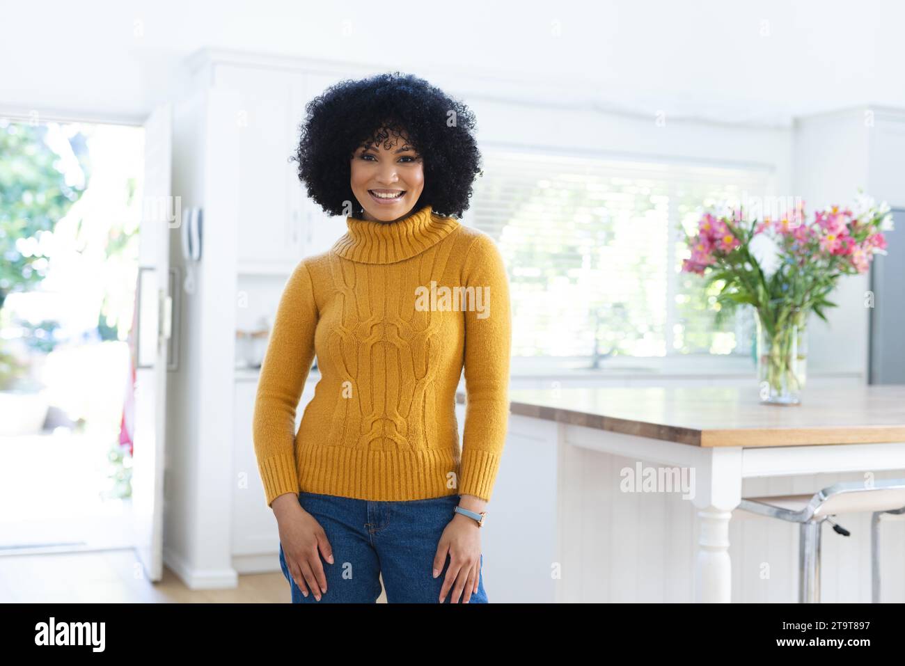 Felice donna afro-americana in piedi con le braccia incrociate a casa, spazio copia. All'interno, espressione, gesticolazione, linguaggio del corpo e femminilità, inalterati Foto Stock