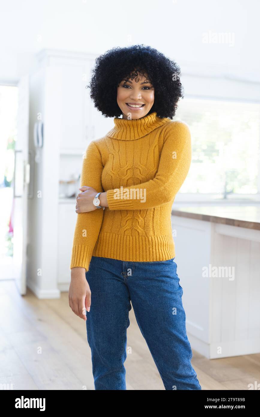 Felice donna afro-americana che tiene la mano a casa, spazio per copiare. All'interno, espressione, gesticolazione, linguaggio del corpo e femminilità, inalterati. Foto Stock