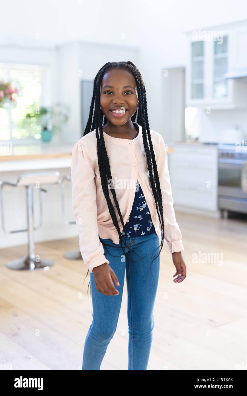 Felice ragazza afro-americana in piedi a casa, spazio per copiare. Infanzia, espressione, gesticolazione e vita domestica, inalterati. Foto Stock