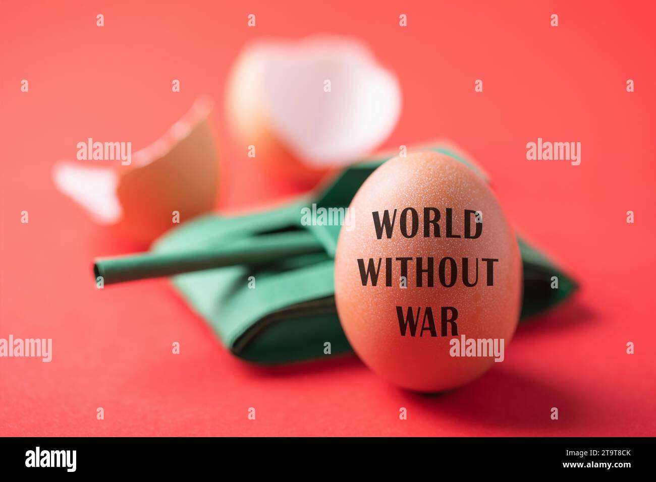 Serbatoio di carta giocattolo, uovo rotto e intero con testo su sfondo rosso, concetto sul tema del mondo senza guerra Foto Stock