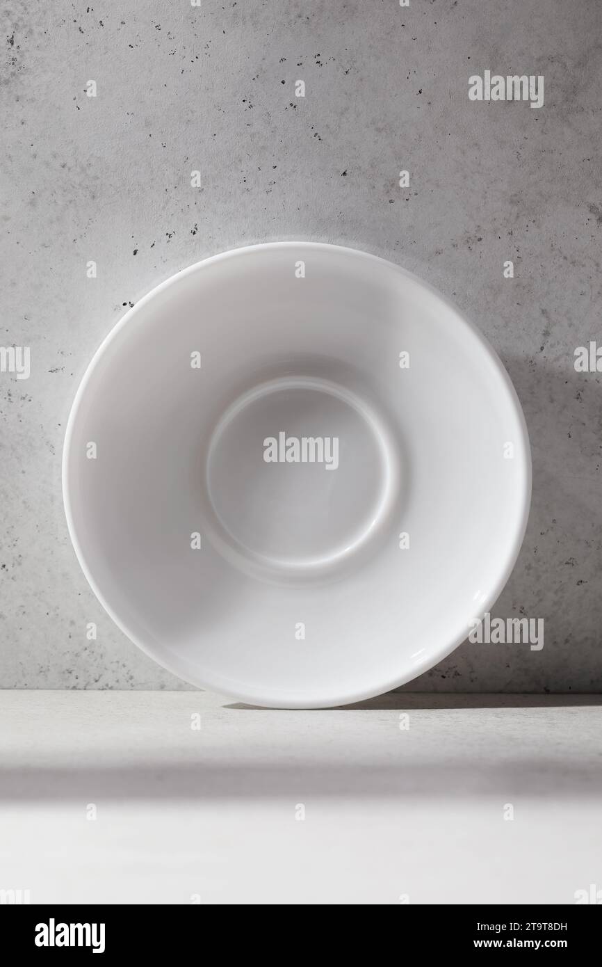 Un piattino in ceramica bianca sul tavolo con motivo astratto Foto Stock