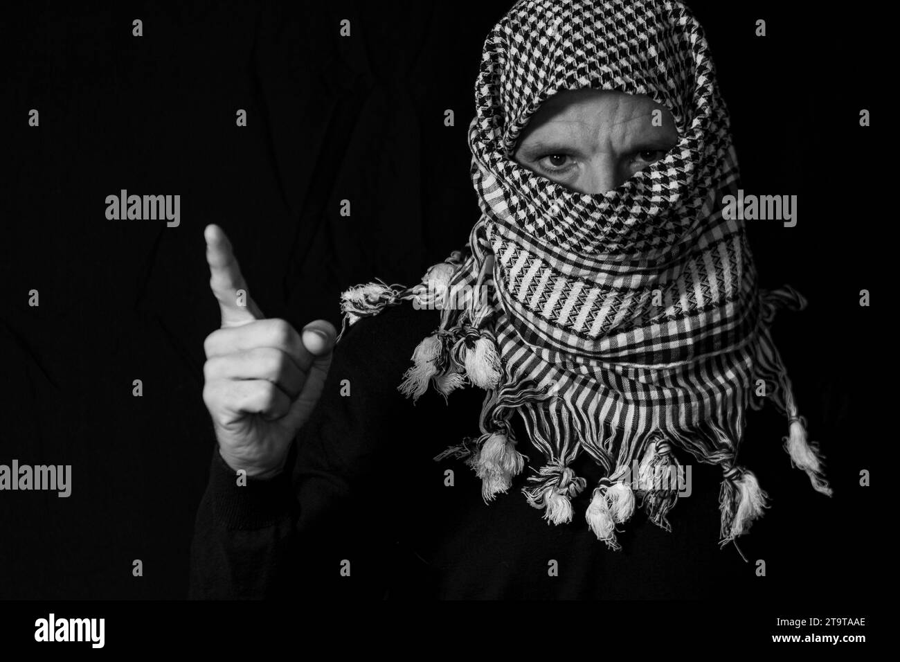 Ritratto uomo adulto con sciarpa palestinese messo sulla testa su sfondo nero Foto Stock