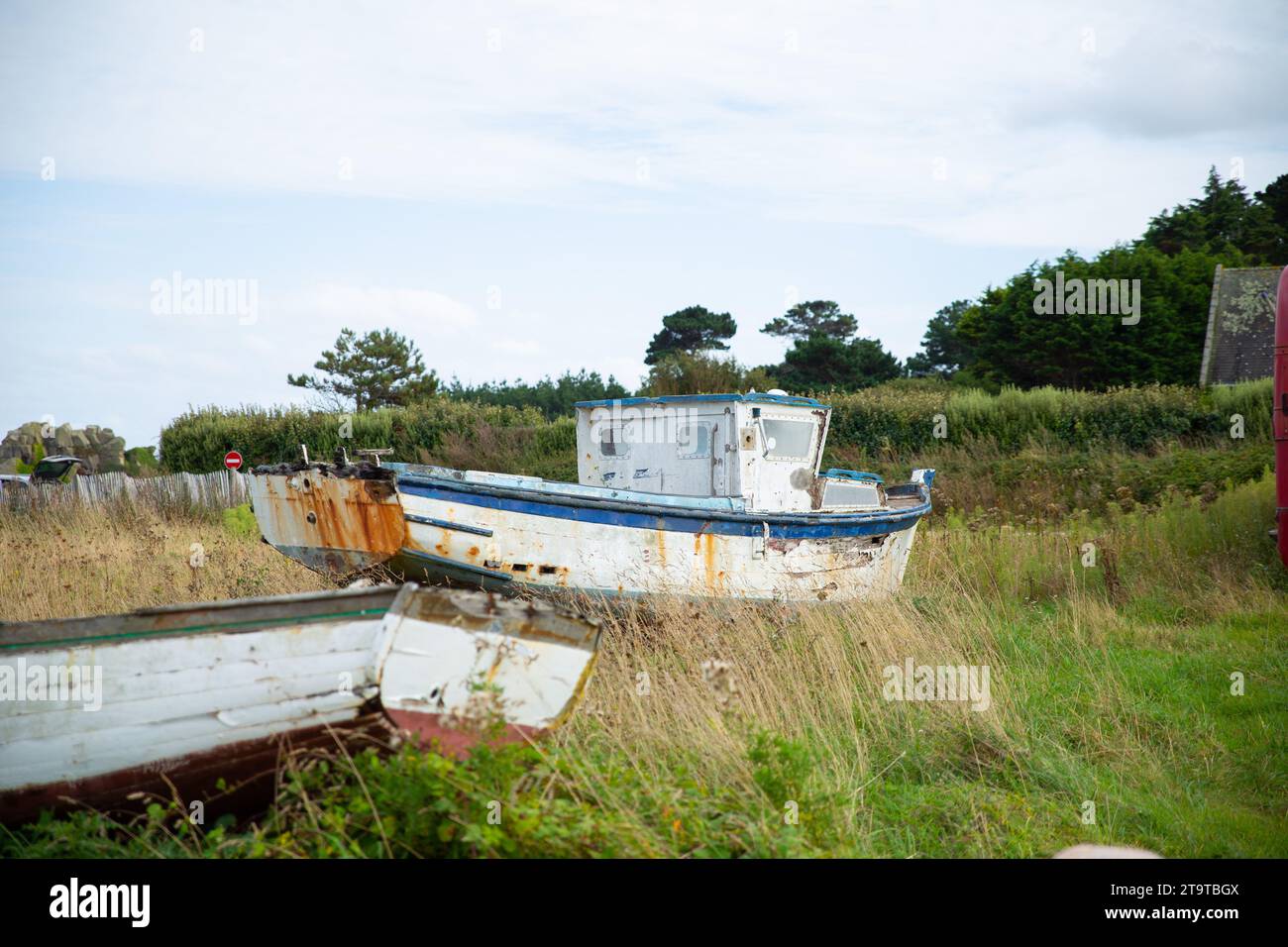 una barca di metallo rotta nell'erba, concetto di tempo Foto Stock