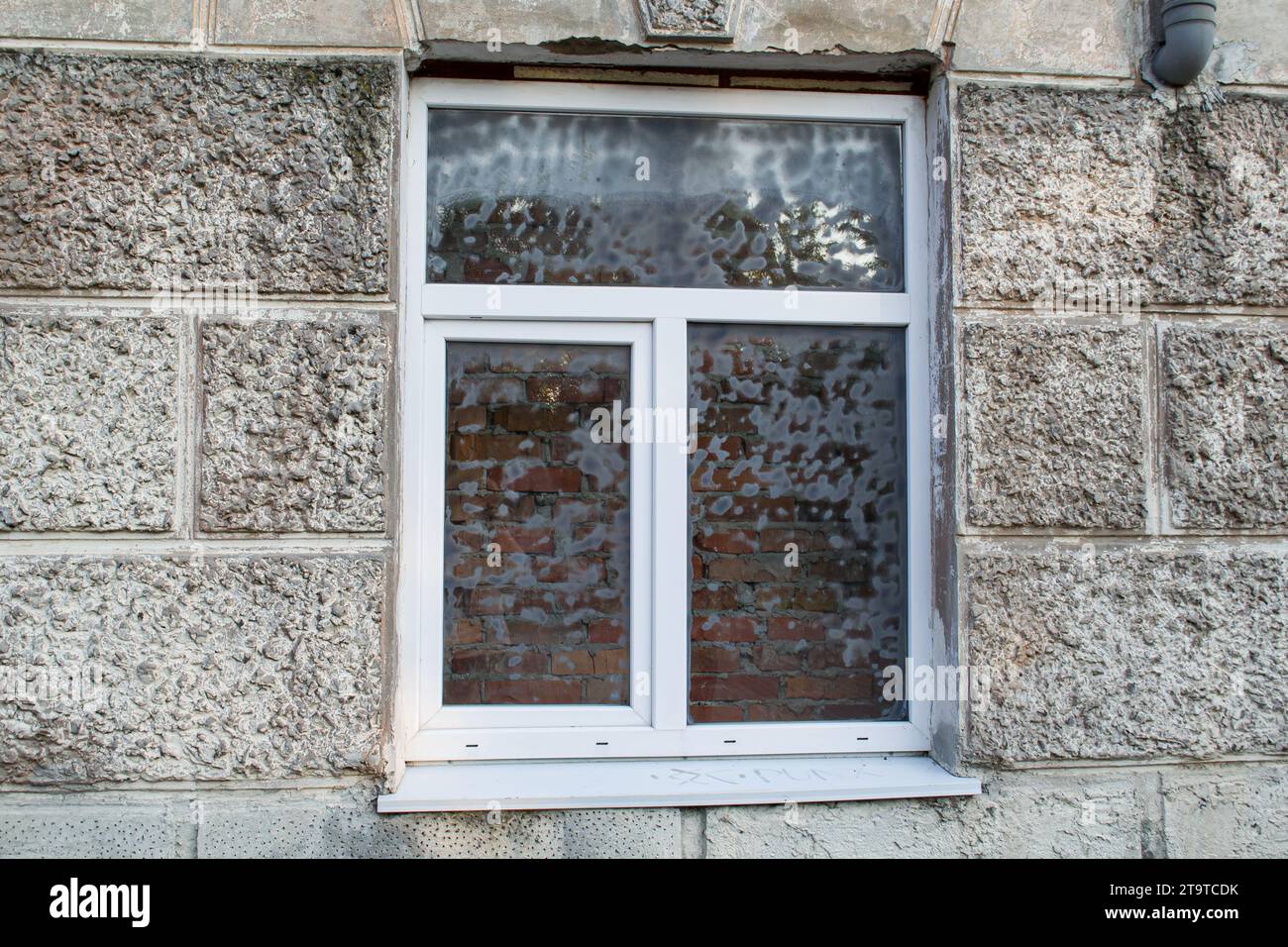 Finestra appena installata con un muro di mattoni dietro di essa Foto Stock