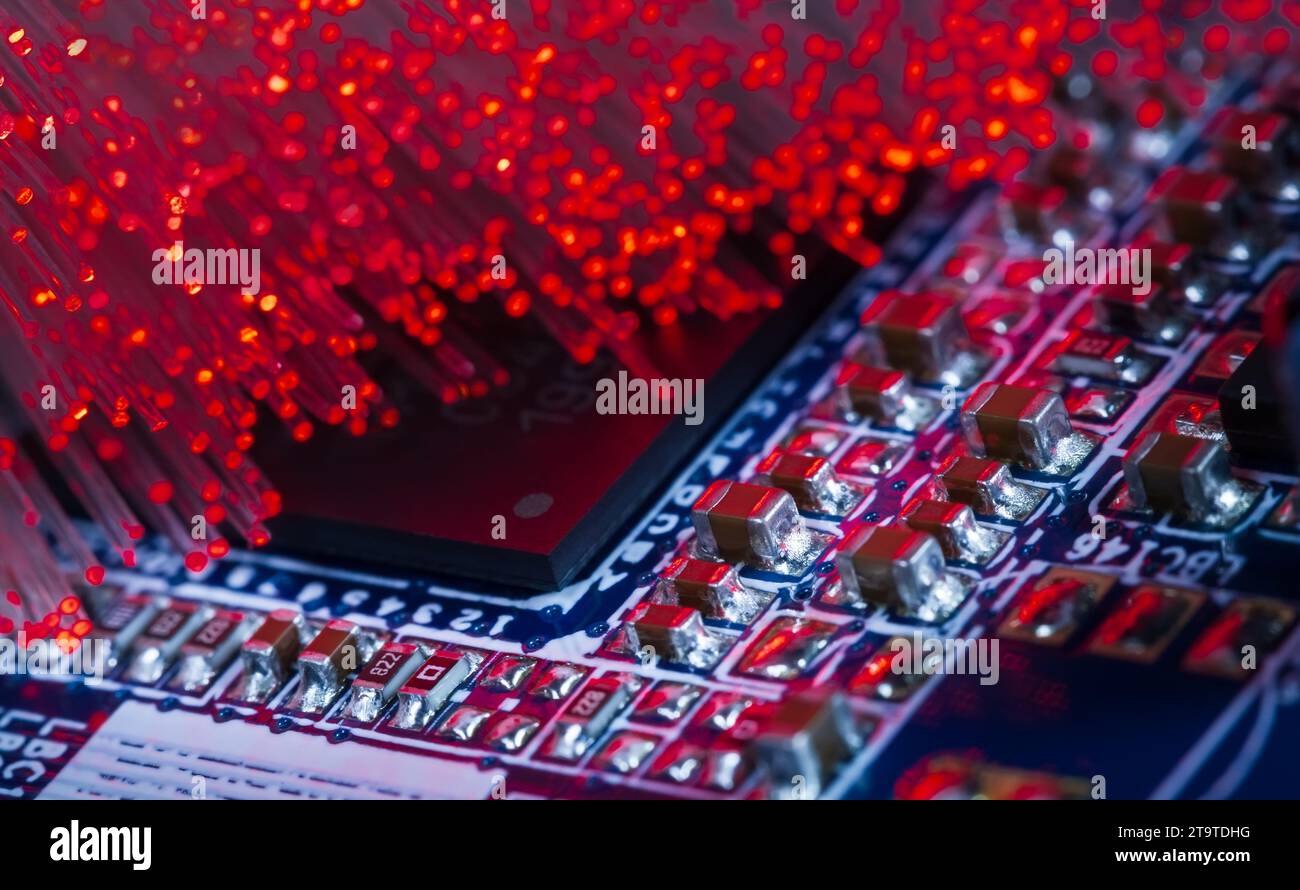 Fotografia macro di una scheda a circuito stampato con processore e fibre ottiche che illuminano la scheda Foto Stock