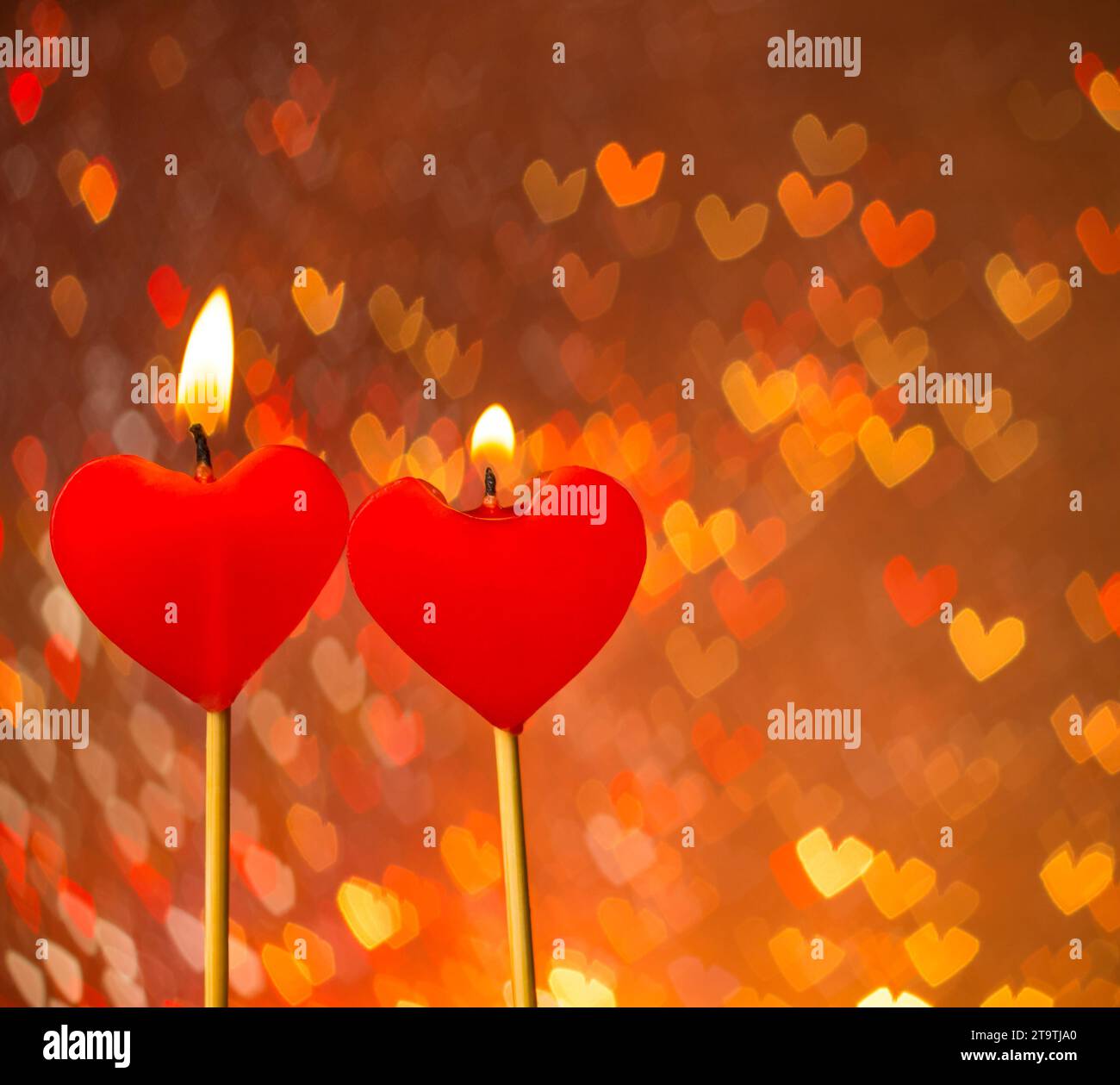 Cuori rossi candele a scaldare i cuori bokeh come sfondo, il giorno di San Valentino e il concetto di amore Foto Stock