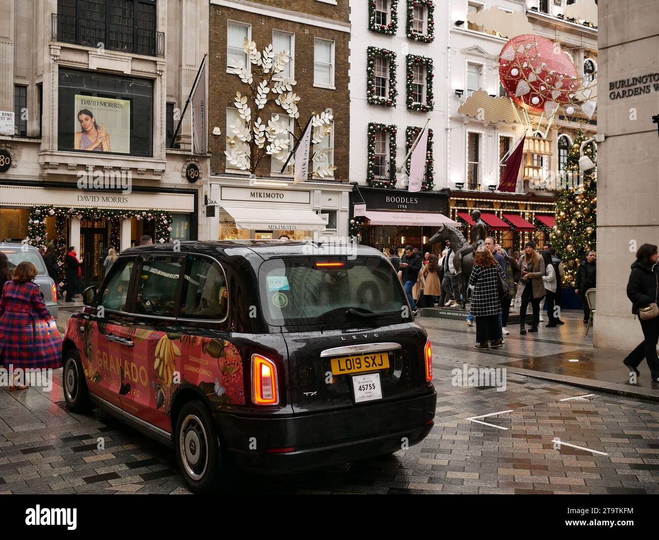 Taxi nero di Londra su Burlington Gardens all'incrocio con Old Bond Street, Londra, Regno Unito Foto Stock
