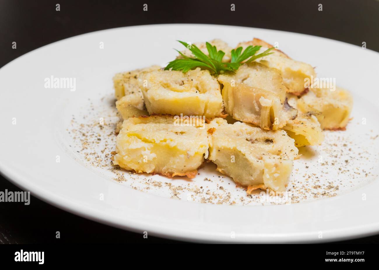 piatto di pasta italiana con funghi porcini e salsa besciamella con pepe su tavola nera Foto Stock