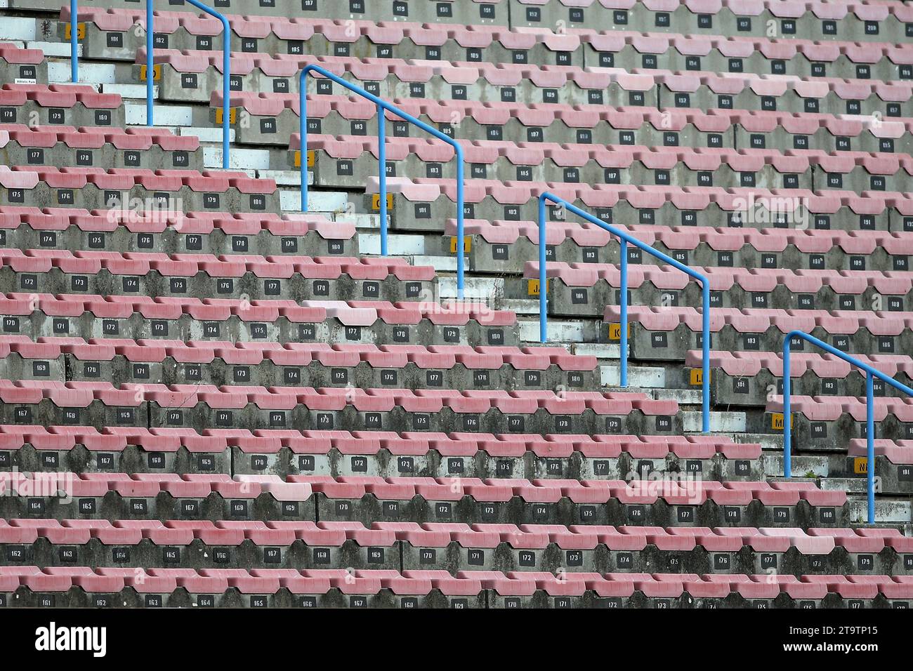File di sedili vuoti per lo stadio. A causa della pandemia mondiale di Covid-19, gli eventi sportivi dal vivo vengono giocati a porte chiuse senza spettatori. Foto Stock