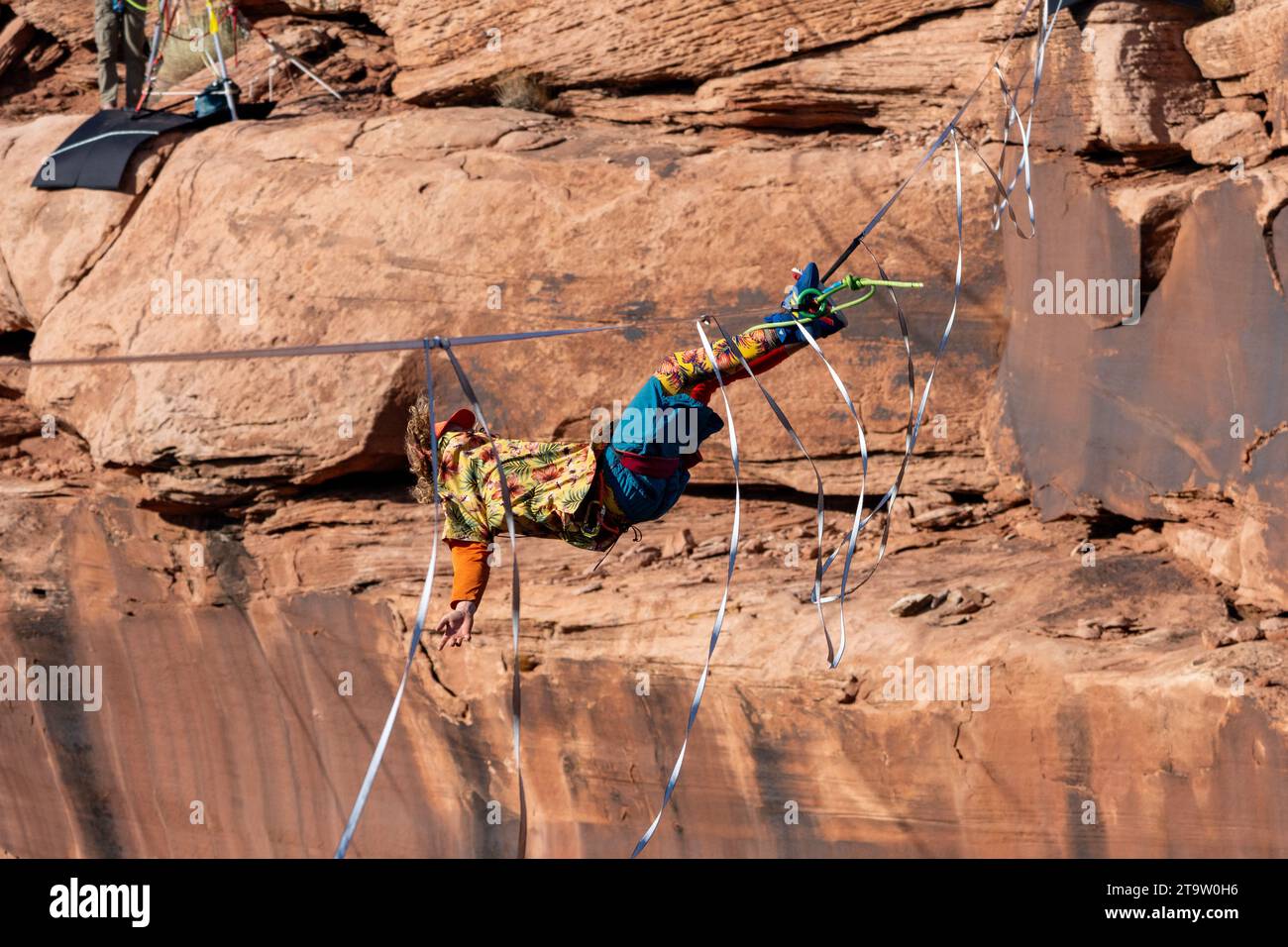 Un freestyler gira intorno a un altopiano, tenendosi con i piedi al GGBY World Highline Festival nel Mineral Canyon vicino a Moab, Utah. Atterra sul suo Foto Stock