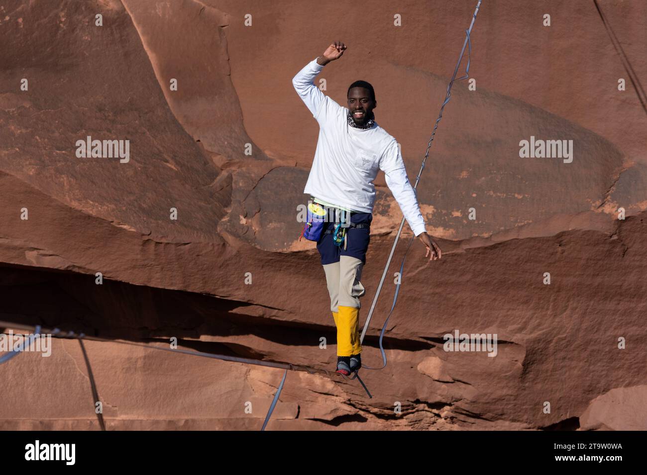 Un giovane nero che cammina su una linea principale al GGBY World Highline Festival nel Mineral Canyon vicino a Moab, Utah. Foto Stock