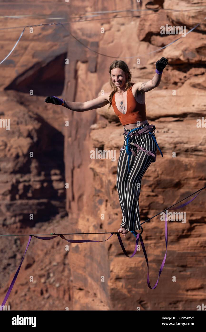 Una giovane donna che cammina su una linea principale al GGBY World Highline Festival nel Mineral Canyon vicino a Moab, Utah. Foto Stock