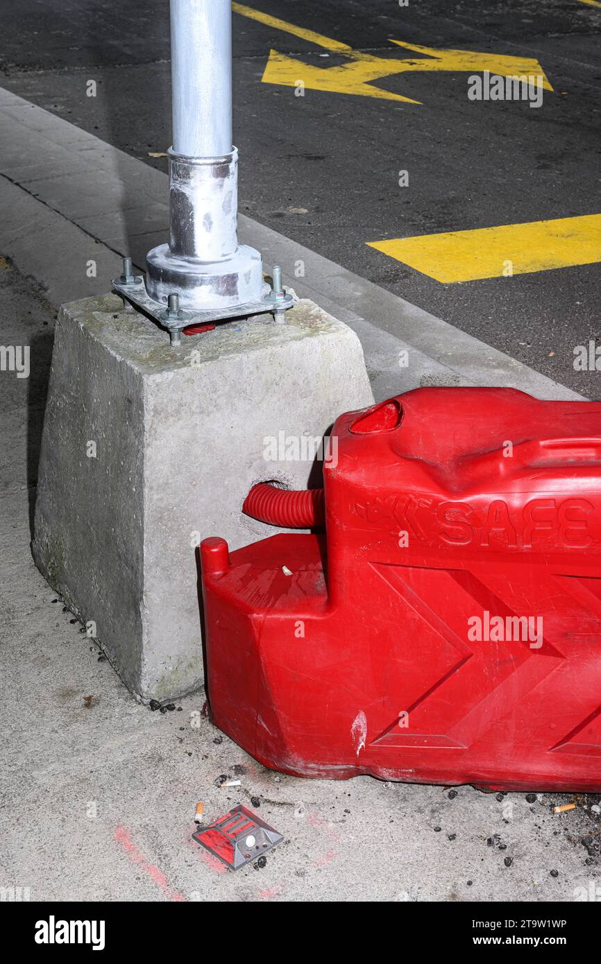 Strada con semafori, linee gialle e barriera protettiva rossa per impieghi pesanti. Foto Stock