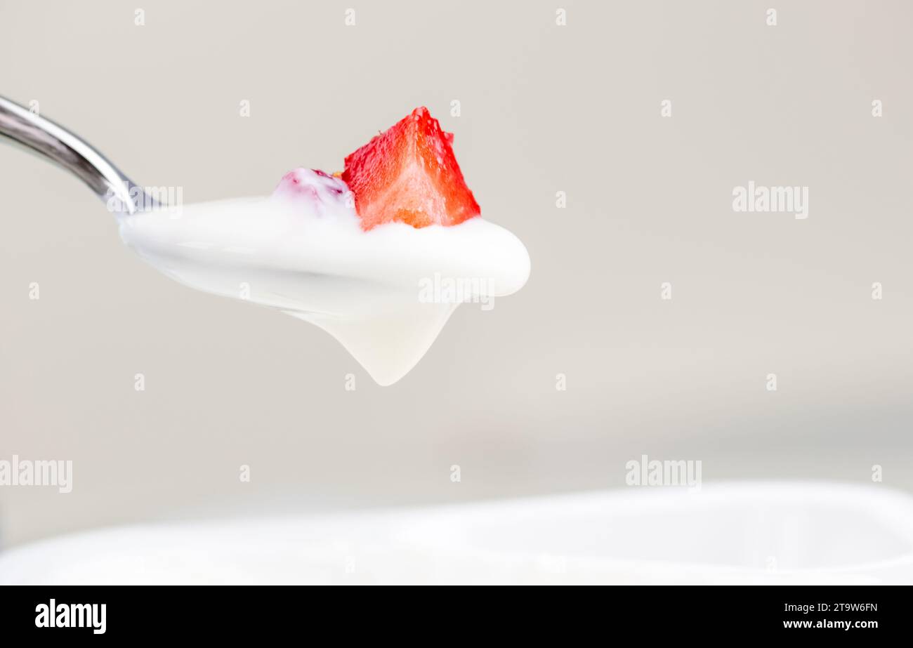 fragola sana e yogurt bianco sul cucchiaio, concetto di nutrizione alimentare sana Foto Stock
