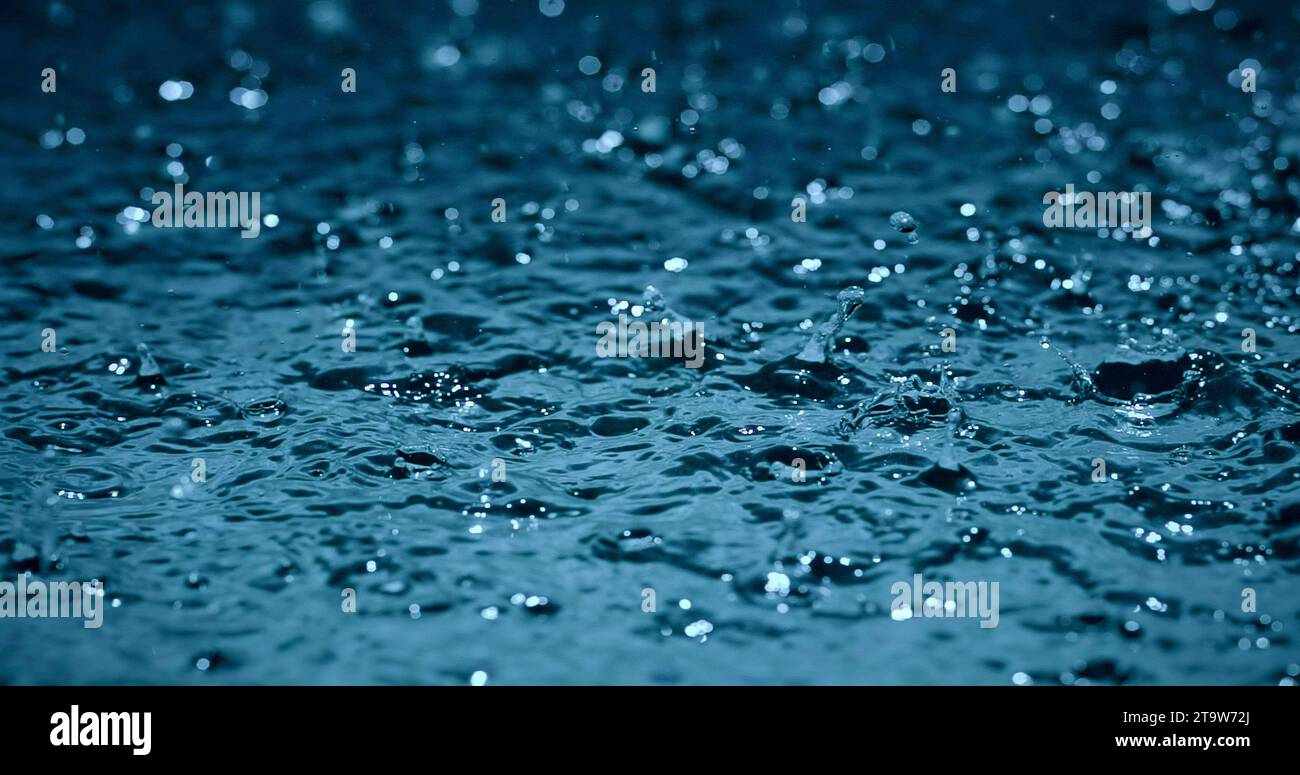 gocce d'acqua piovana al rallentatore sulle strade di superficie Foto Stock