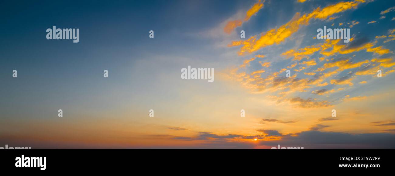 scena del tramonto con sole che cade e raggi di luce, nuvole sullo sfondo, cielo caldo e colorato con nuvole soffuse Foto Stock