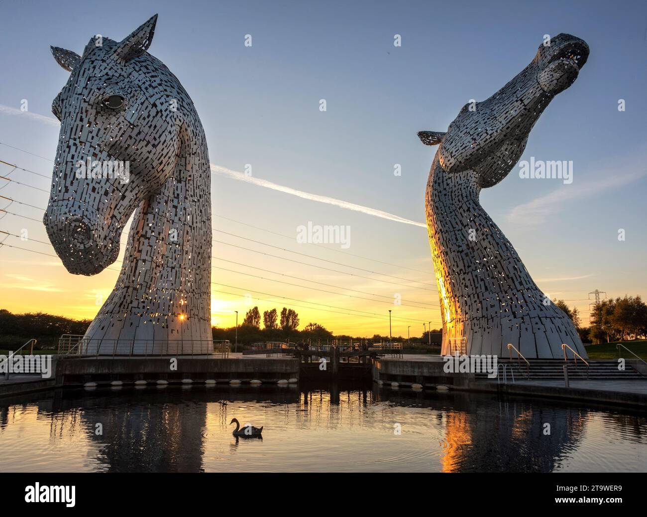 Le Kelpies, sculture a testa di cavallo alte 30 metri (98 piedi) raffiguranti kelpies, a Grangemouth, Scozia, fotografate alla luce dal tramonto del sole. Foto Stock