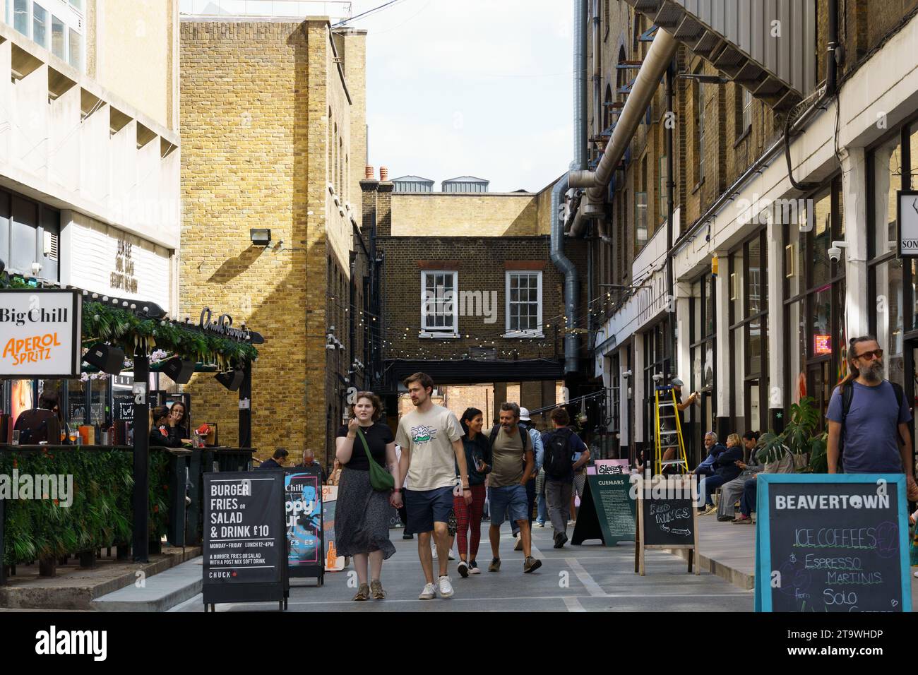 Londra, Regno Unito - 25 agosto 2023: Scena di strada con gente che fa shopping a Dray Walk, una strada pedonale vicino a Brick Lane nell'area di Shoreditch nell'East End Foto Stock
