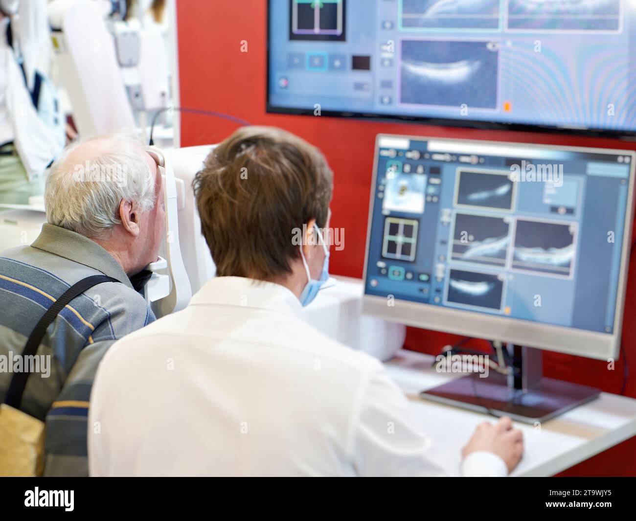 Medico e paziente con tomografo ottico coerente oftalmico spettrale e monitor Foto Stock