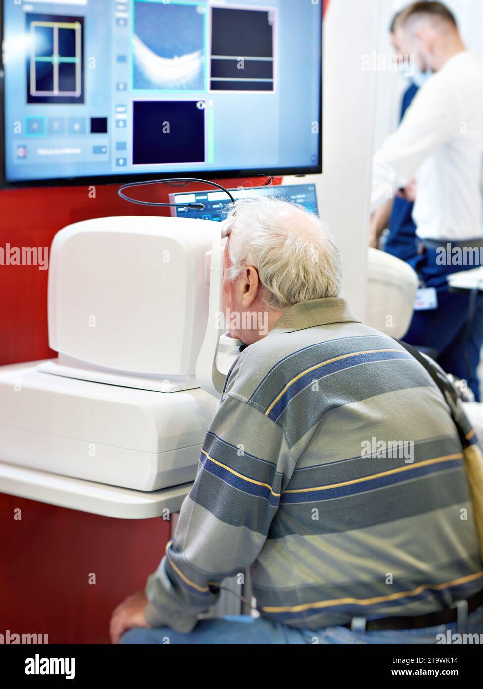 Paziente con tomografia ottica coerente oftalmica spettrale e monitor Foto Stock