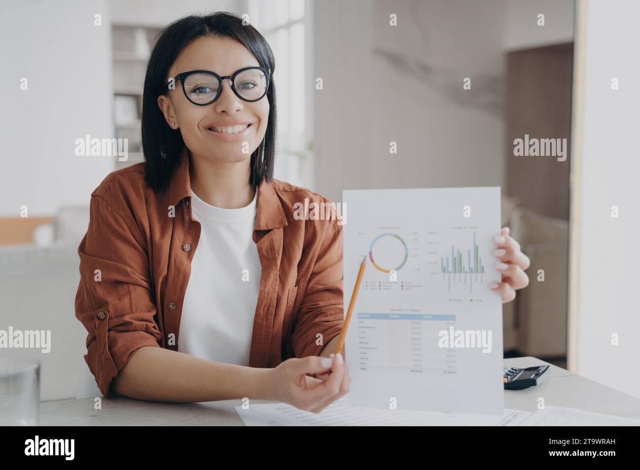 Un professionista sicuro che presenta un grafico dei dati finanziari, sorridente Foto Stock
