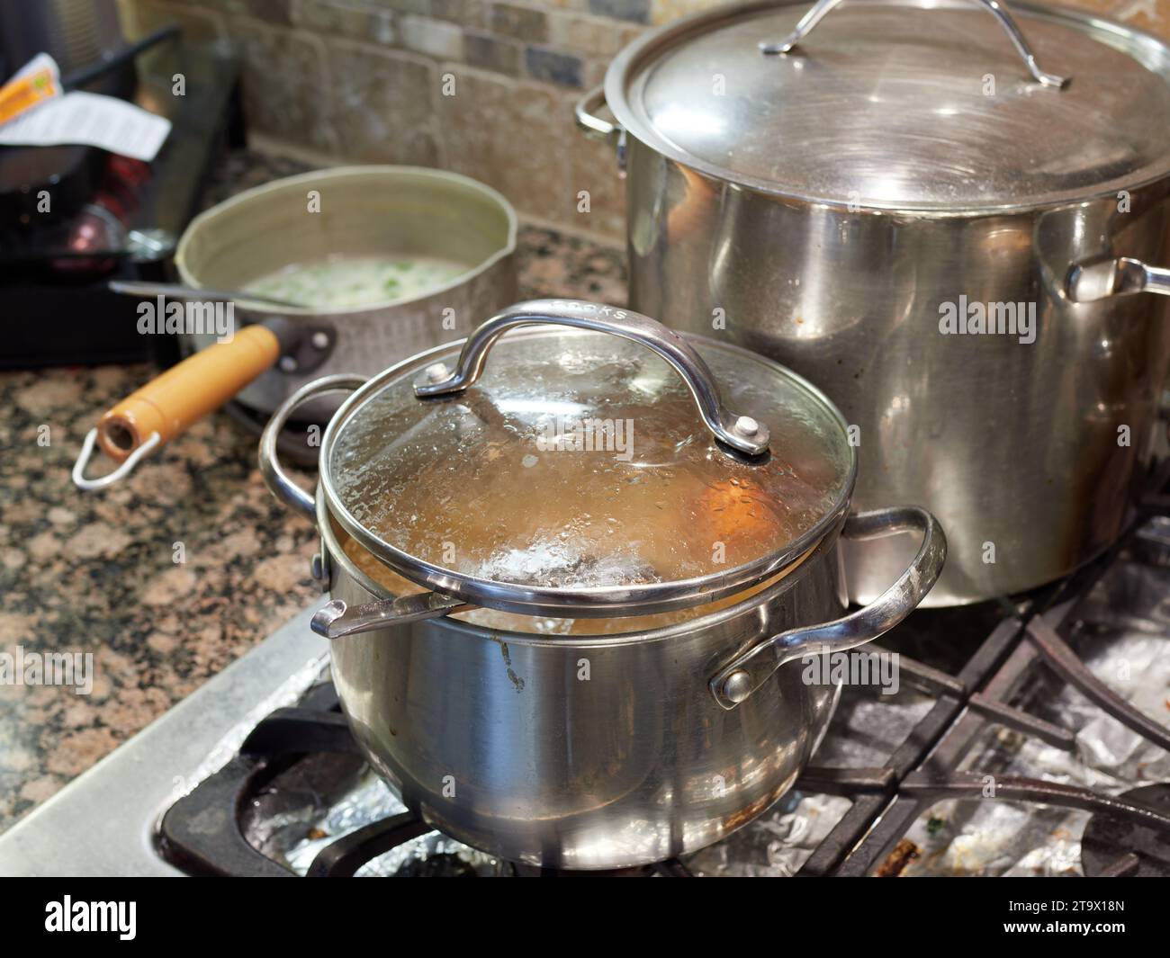 Pentole e padelle che cucinano su un piano cottura a gas in una casa o in una casa di famiglia. Foto Stock