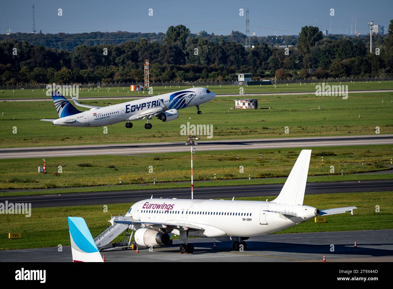 Aeroporto di Düsseldorf, Egyptair Airbus A321neo al decollo, Eurowings Airbus in posizione di parcheggio Foto Stock