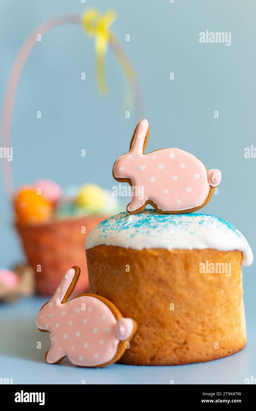Primo piano di due pan di zenzero rosa sotto forma di coniglio sulla torta pasquale Foto Stock
