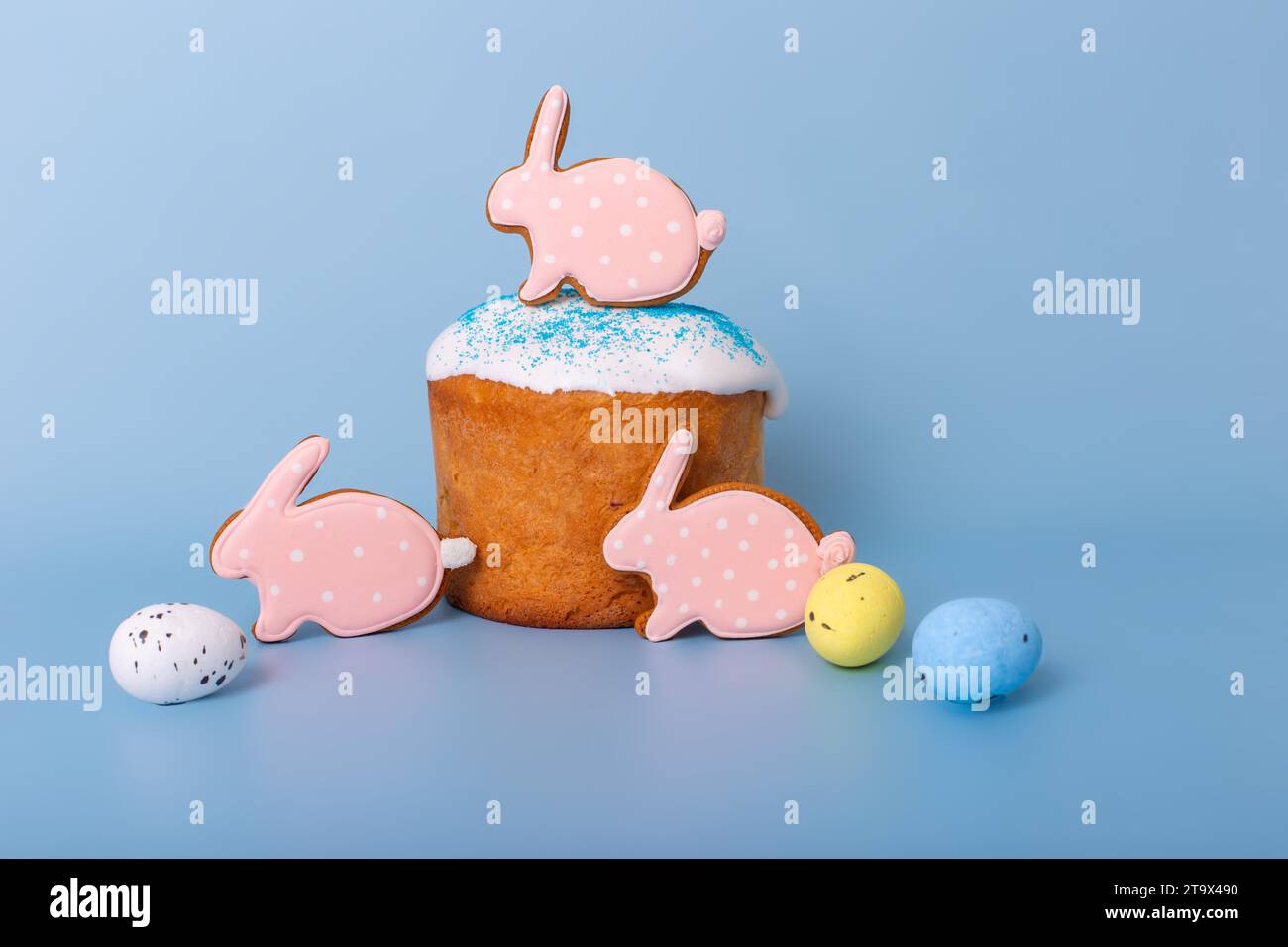 Tre graziosi pani di zenzero rosa a forma di coniglio sulla torta pasquale Foto Stock