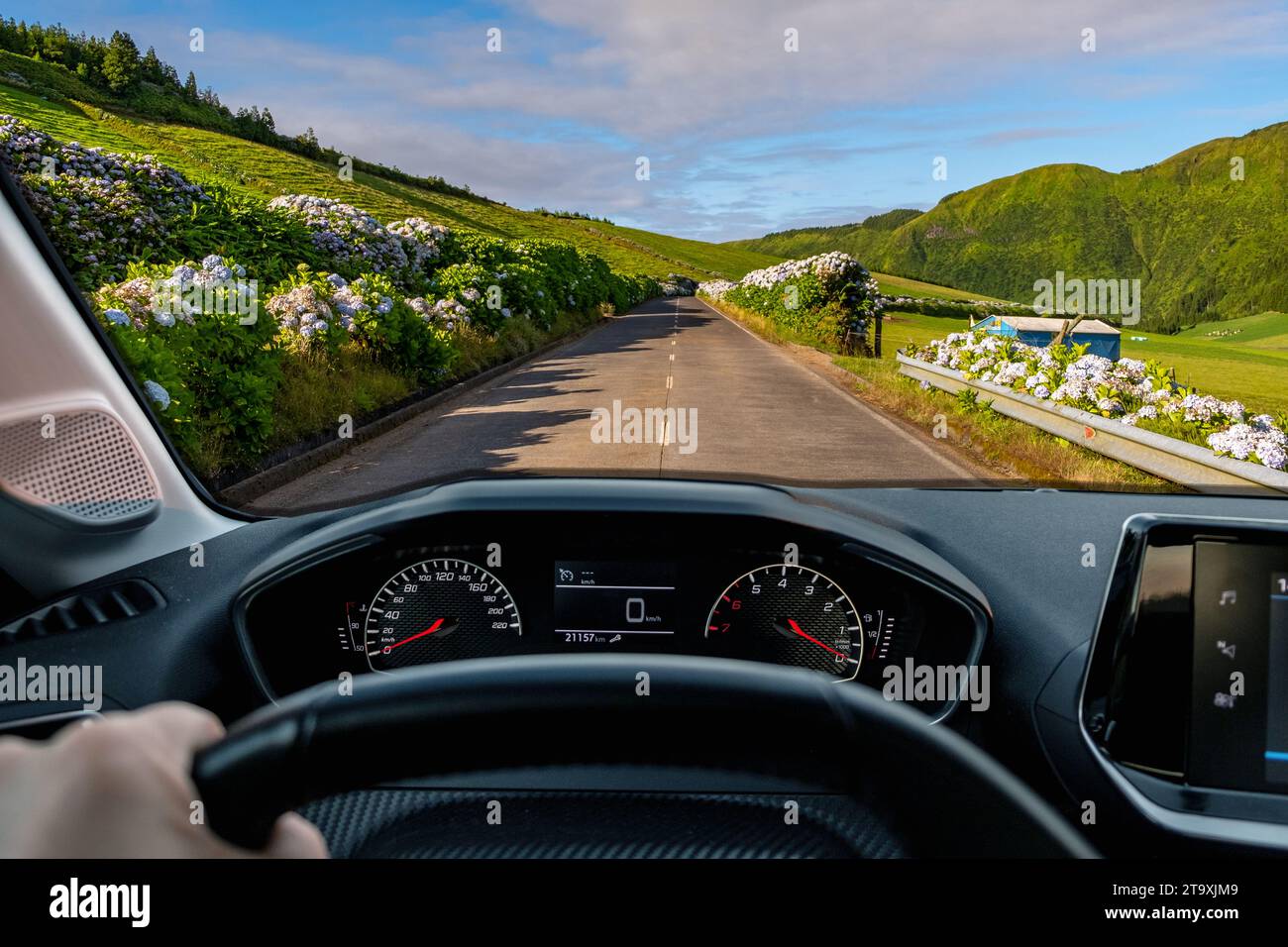 Vista del conducente sulla strada con una splendida vista del paesaggio verde dall'interno dell'auto bloccata del conducente POV del paesaggio stradale. Isola di São Miguel nelle Azzorre Foto Stock