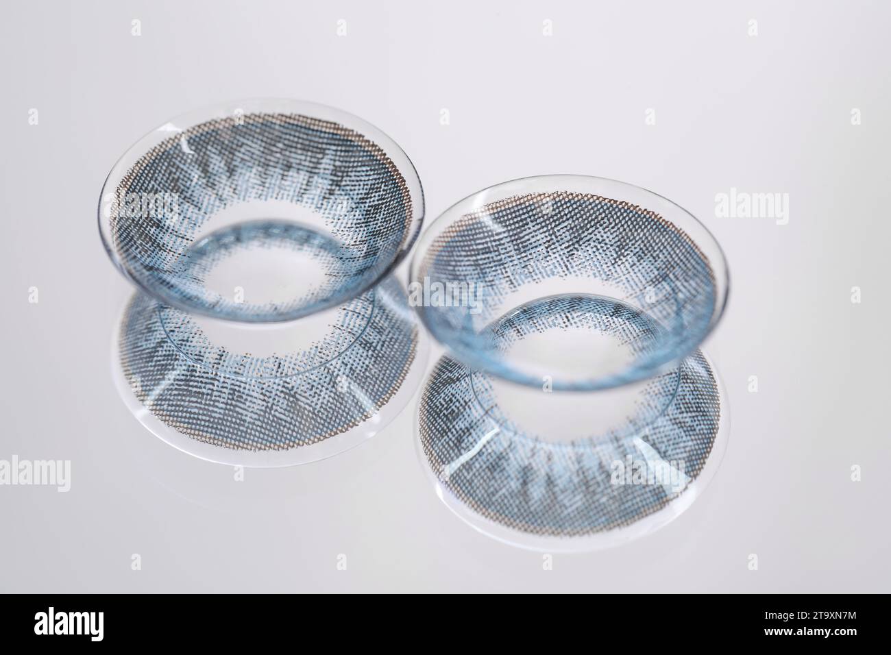 Due lenti a contatto blu sulla superficie dello specchio Foto Stock