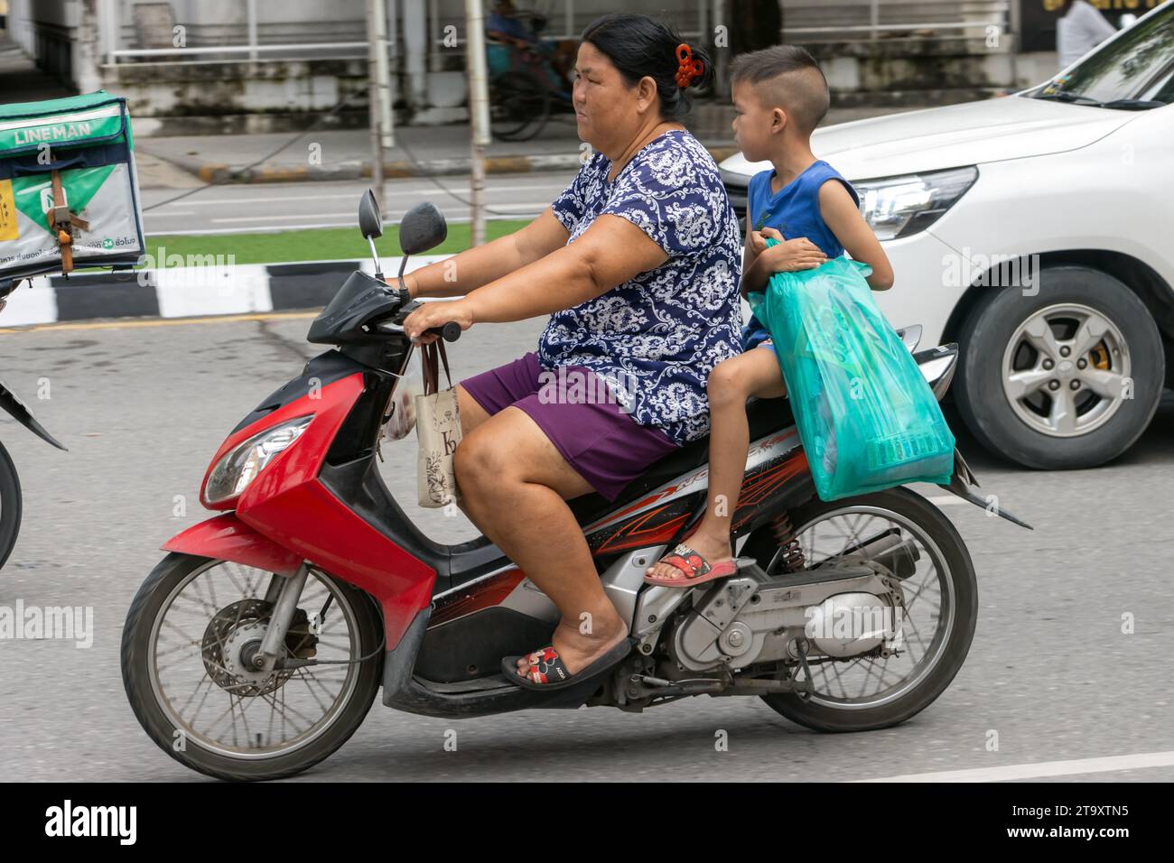 SAMUT PRAKAN, THAILANDIA, 11 ottobre 2023, Una donna cavalca con un ragazzo su una moto. Foto Stock