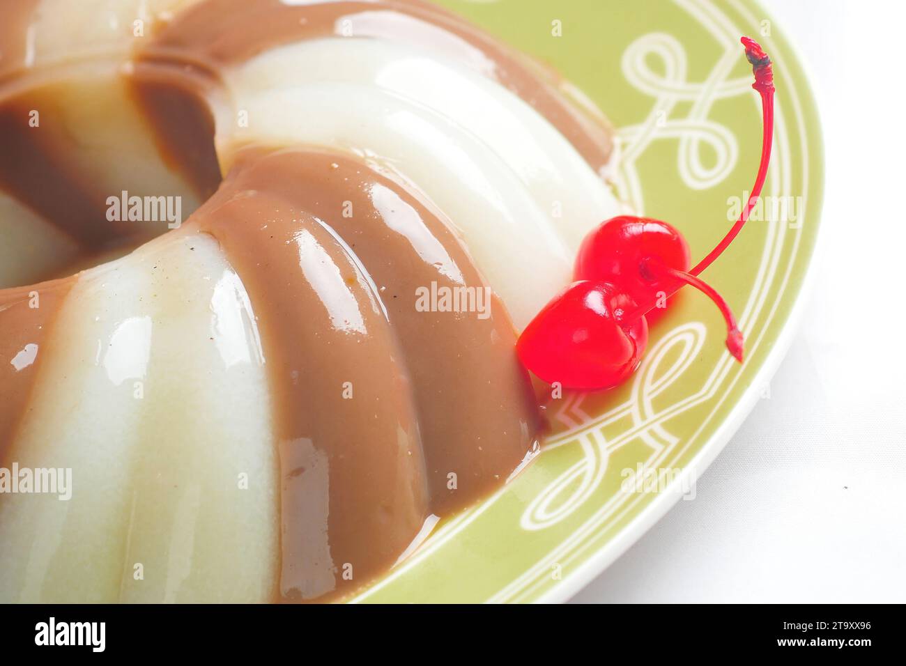 Pudding di gelatina guarnito con ciliegia Foto Stock
