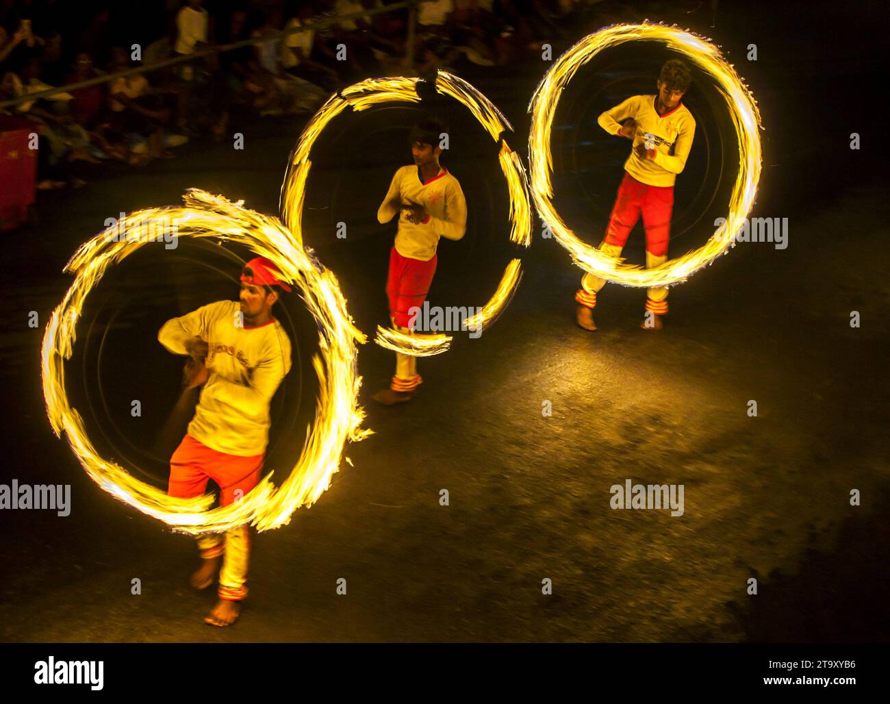 I ballerini di fuoco si esibiscono lungo una strada di Kandy in Sri Lanka durante l'Esala Perahera (grande processione). Foto Stock