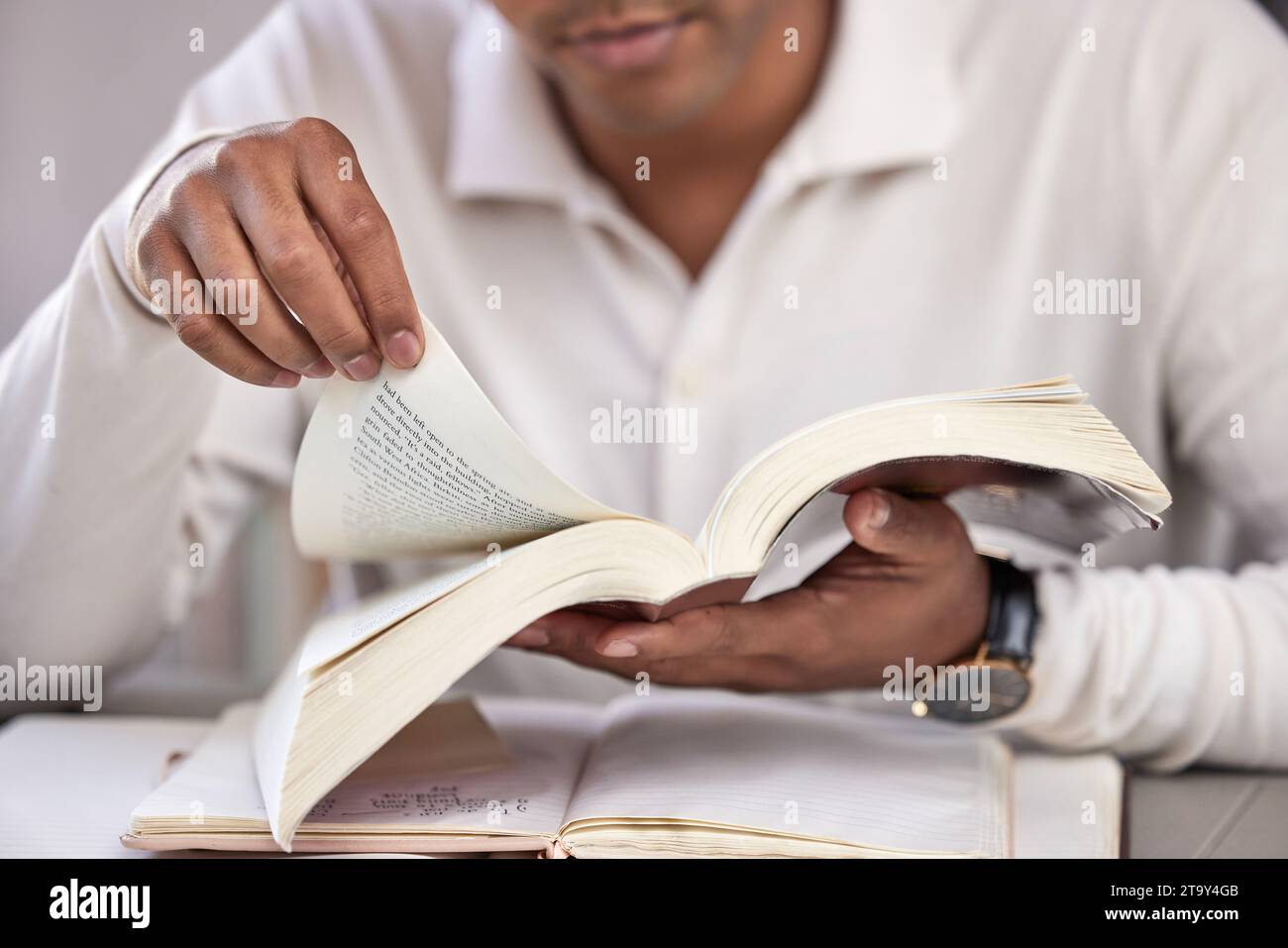 Le mani, l'uomo e la bibbia studiano alla scrivania, a casa e leggono per la fede, la conoscenza e la guida spirituale. Libri personali, quaderni e di religione disponibili sul tavolo Foto Stock