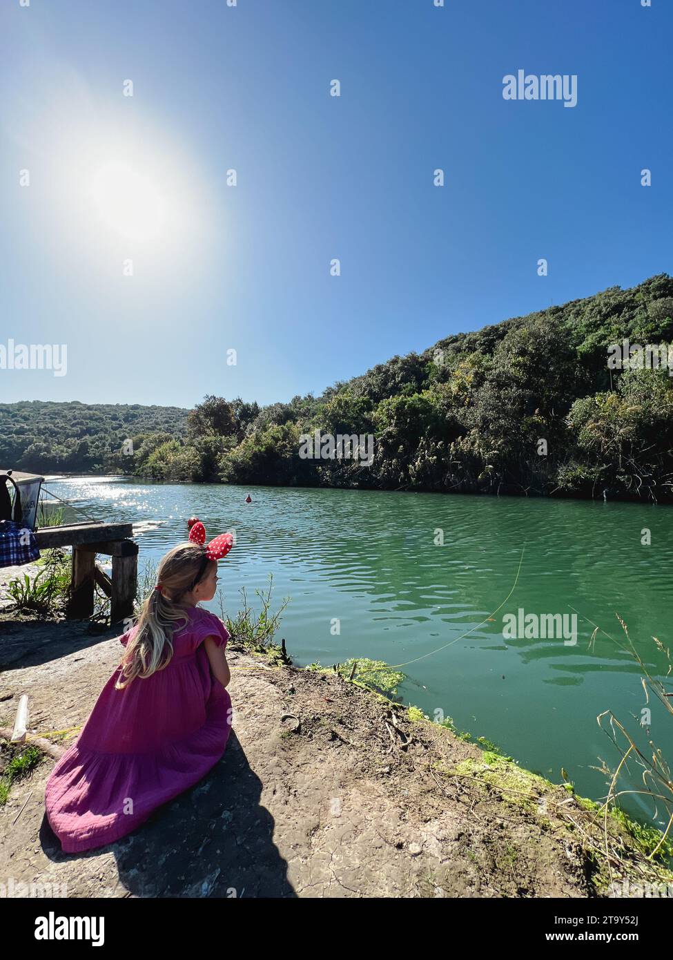 La bambina con le orecchie di Minnie mouse sulla testa e una rete di  atterraggio nelle sue mani cammina lungo la riva del fiume Foto stock -  Alamy