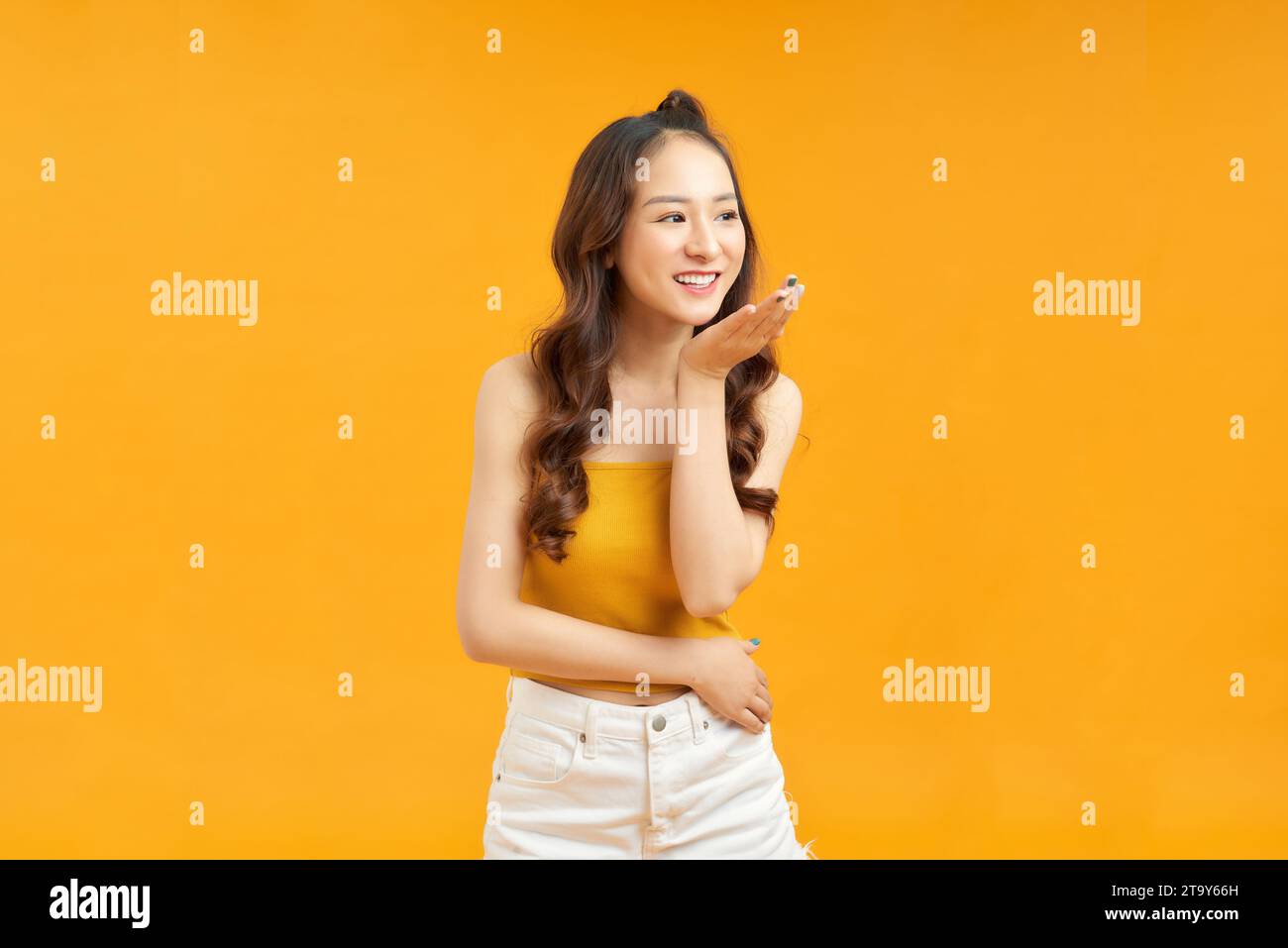 Bella giovane modella asiatica carina con trecce di capelli in piedi in posa guardare la macchina fotografica Foto Stock