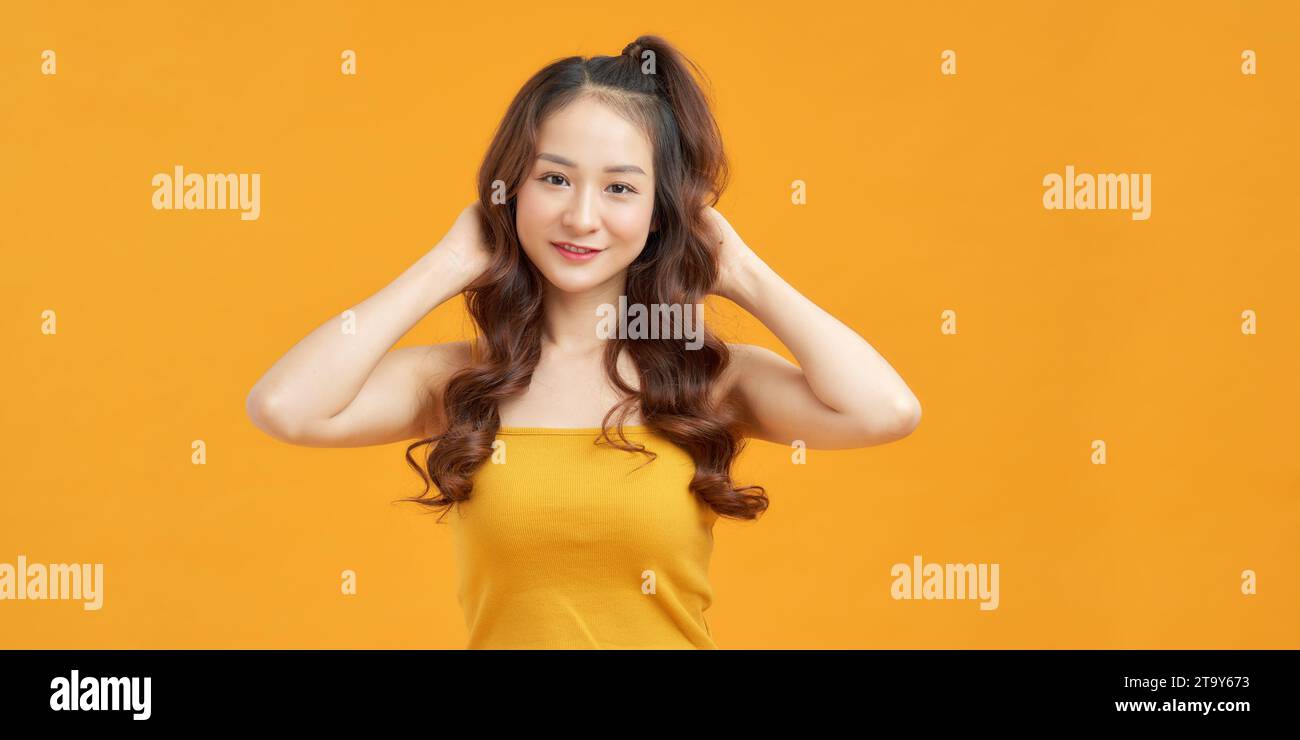 Bella giovane modella asiatica carina con trecce di capelli in piedi in posa guardare la macchina fotografica Foto Stock