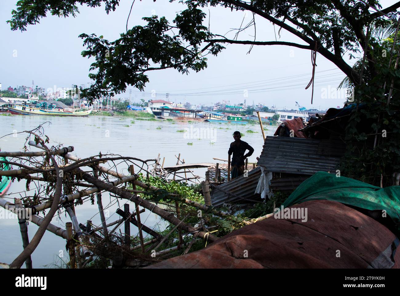 Stazione tradizionale per imbarcazioni da carico accanto alla riva del fiume. Una pittoresca scena si svolge lungo le rive del fiume Bangladesh, mentre le tradizionali barche da carico trovano la loro posizione Foto Stock